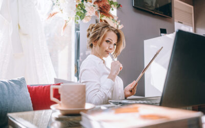 young woman wedding planner in office with laptop and tablet for writing